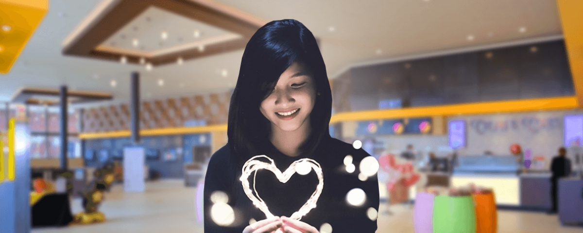 Filmgoer holding a heart shape in a cinema foyer