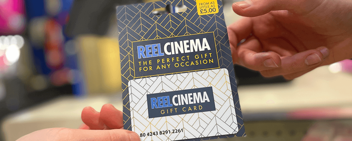 A REEL Cinema gift card being given to a customer